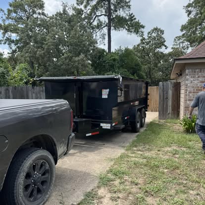 Dumpster trailer backed into a residential driveway