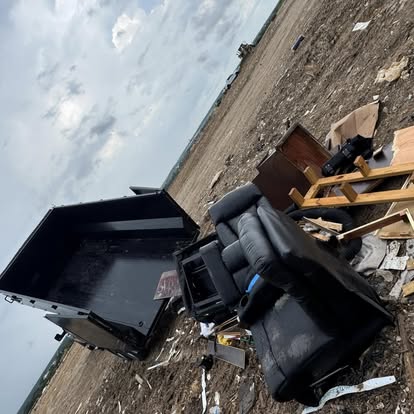 Dump trailer tipping furniture and debris at a landfill