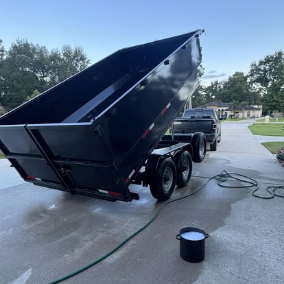 Dump trailer raised in a driveway during cleanup
